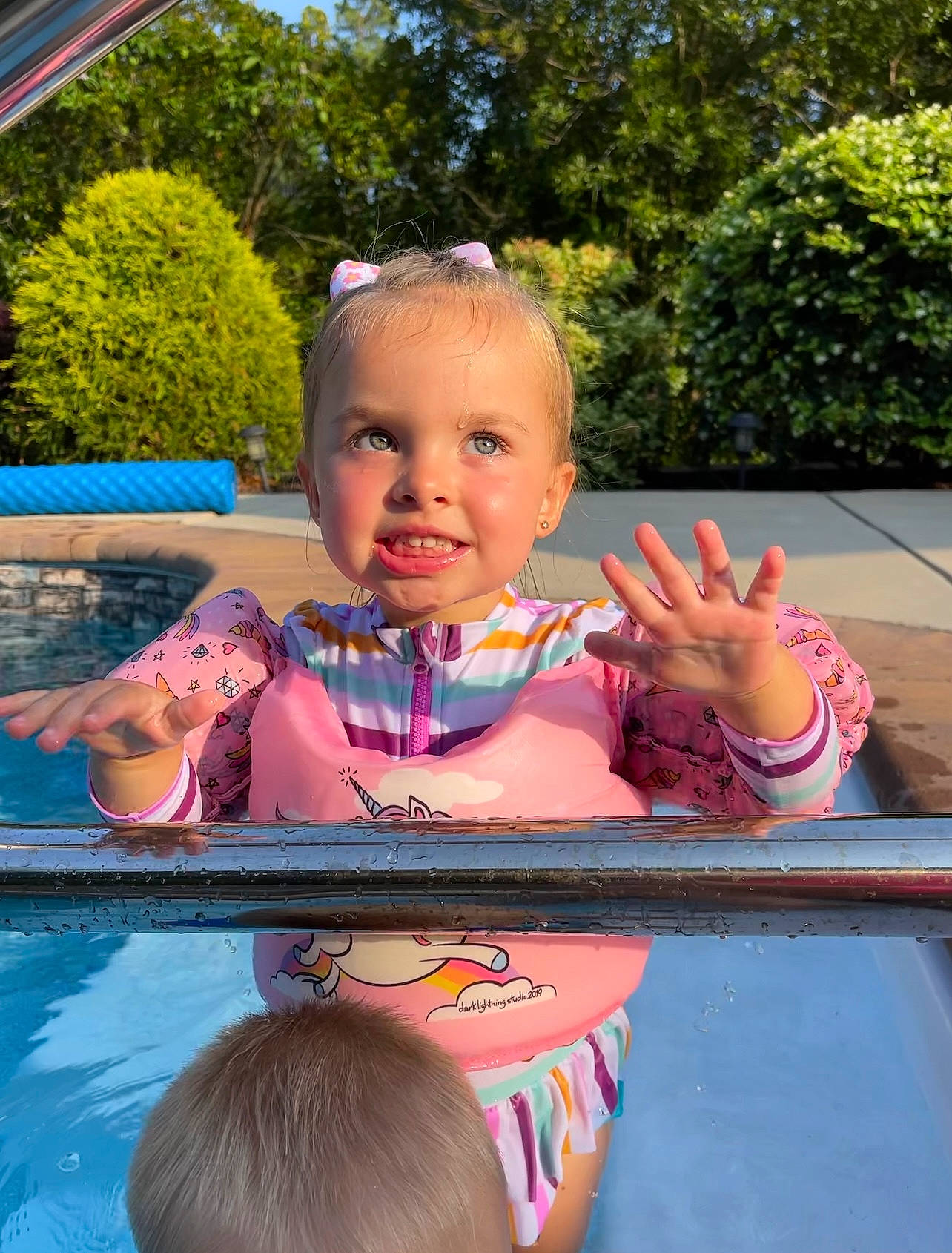 Sky'Lee is registered to the contest to win money with this photo: baby, chair, child, event, facial_expression, finger, fun, grass, happy, joy, leisure, person, pink, pool, recreation, sitting, smile, swimming_pool, t_shirt, toddler