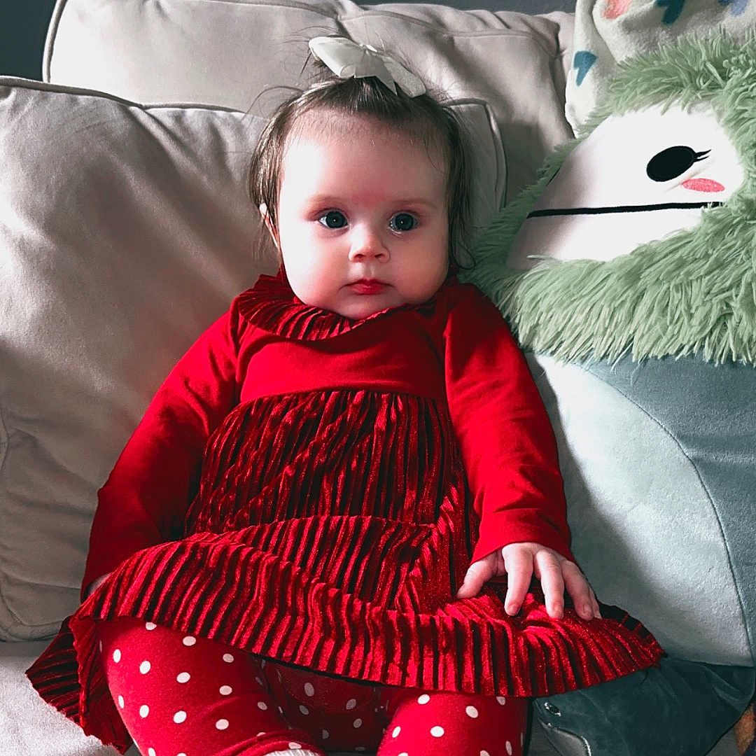 Trinity is registered to the contest to win money with this photo: baby, bodypart, clothing, couch, cushion, face, finger, furniture, hand, happy, head, homedecor, hosiery, knitwear, person, photography, portrait, sitting, smile, sock