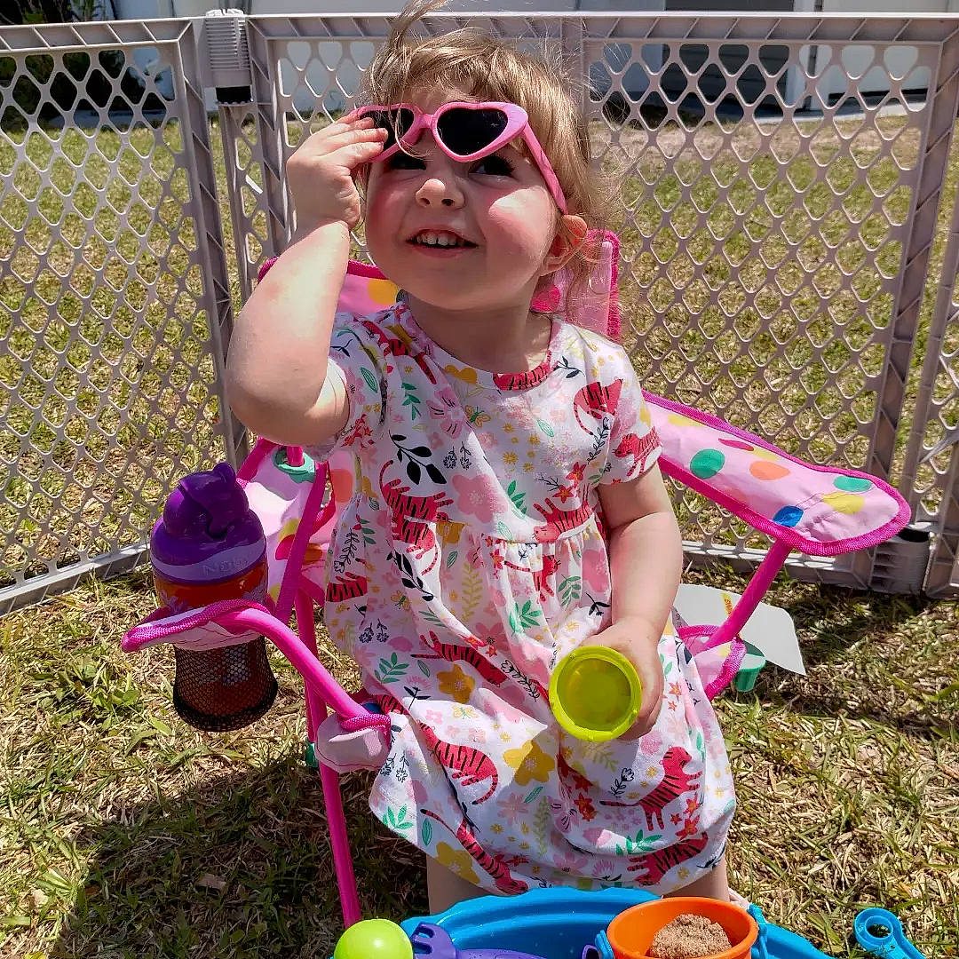 Hailey is registered to the contest to win money with this photo: baby_toddler_clothing, child, easter, eyewear, fence, fun, goggles, grass, mesh, pattern, person, play, recreation, soil, summer, sunglasses, t_shirt, tableware, toddler, vision_care