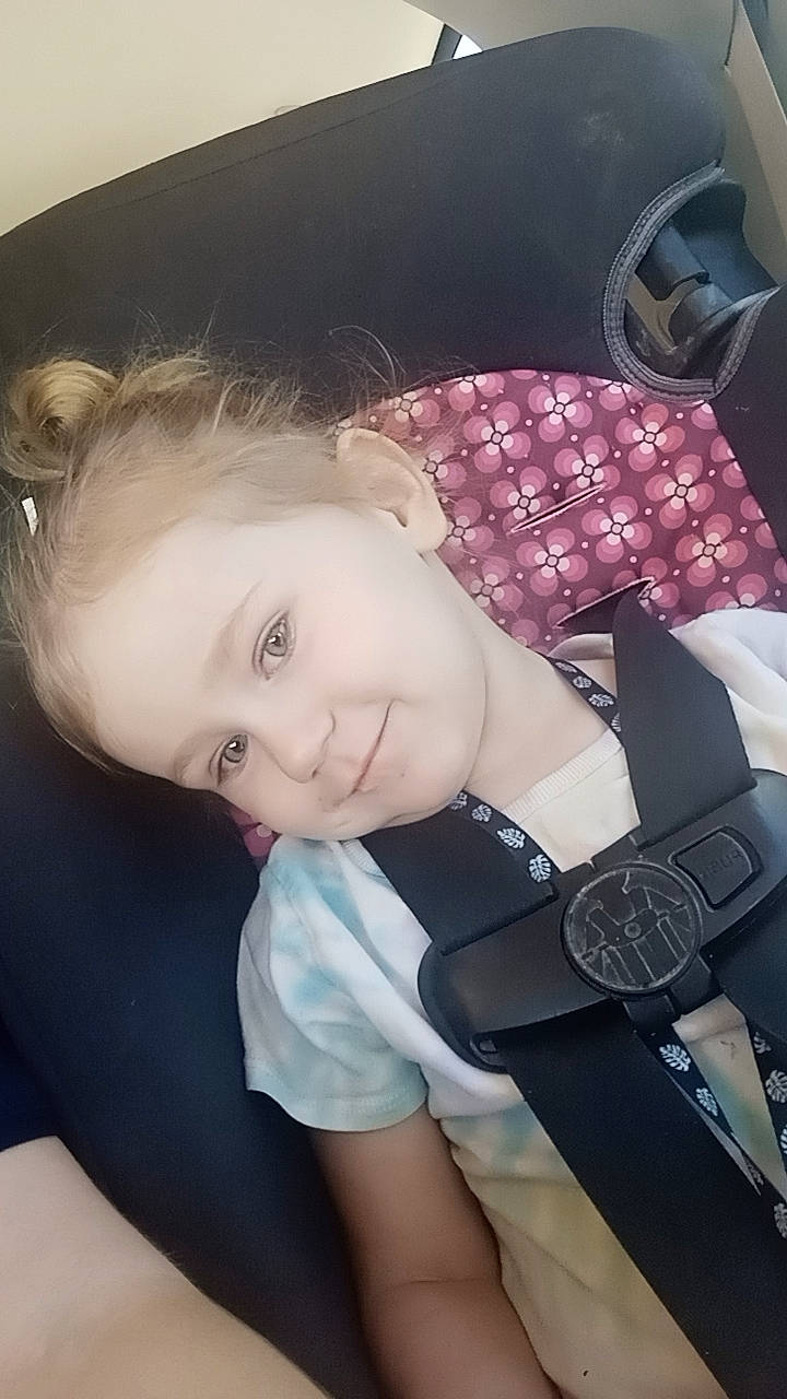 Flora is registered to the contest to win money with this photo: black_hair, blond, child, cool, elbow, eyelash, eyewear, fashion_accessory, finger, flash_photography, happy, human_leg, joy, lip, material_property, person, sitting, smile, thigh, toddler