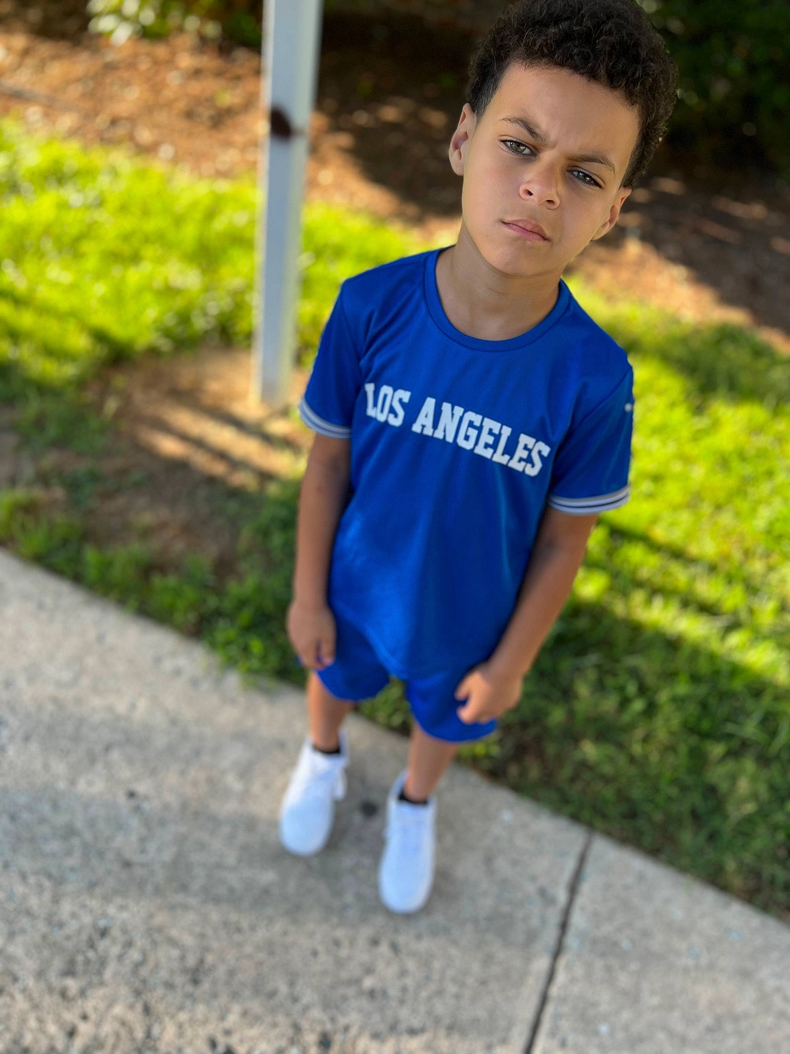 Kingston is registered to the contest to win money with this photo: child, chin, denim, electric_blue, eye, face, fun, grass, hair, happy, head, leisure, person, plant, recreation, sitting, sleeve, sportswear, t_shirt, toddler