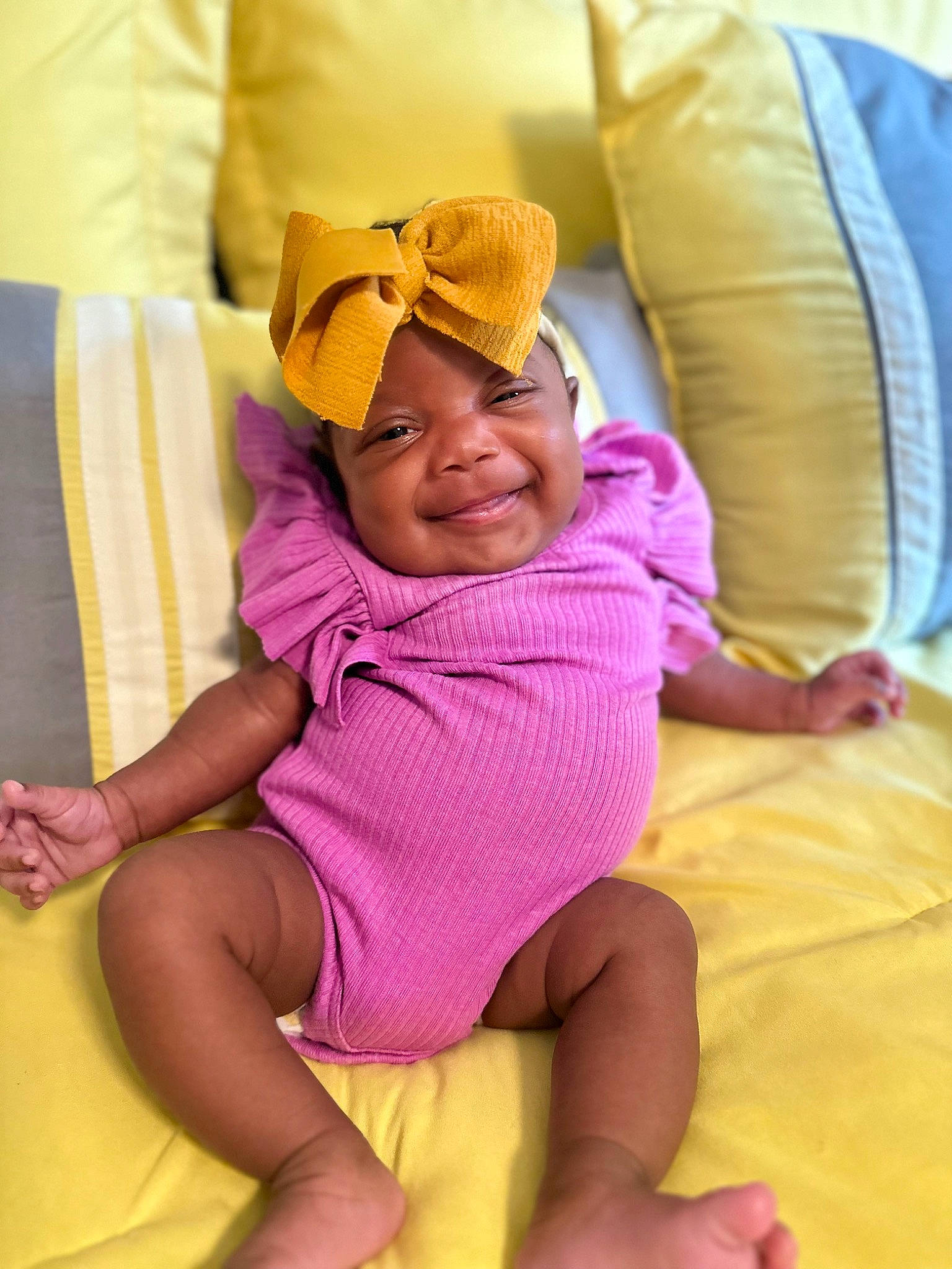 Brielle joined the competition — help win amazing prizes! baby, baby_toddler_clothing, chair, comfort, couch, finger, happy, hat, head, headwear, joy, knee, leg, linens, magenta, person, pink, purple, smile, textile