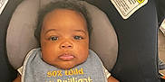 Lenox joined the competition — help win amazing prizes! baby, infant, car_seat, chicco, bib, clothing, face, child, cute, serious_expression, text_on_clothing, seatbelt, safety_warning, indoor, person, head, arm, skin, young_child, closeup