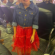 Charlee is registered to the contest to win money with this photo: adults, bag, carpet, chairs, child, cute, denim_shirt, dress, event, fashion, girl, happy, indoor, people, person, portrait, red_skirt, shoes, smiling, window
