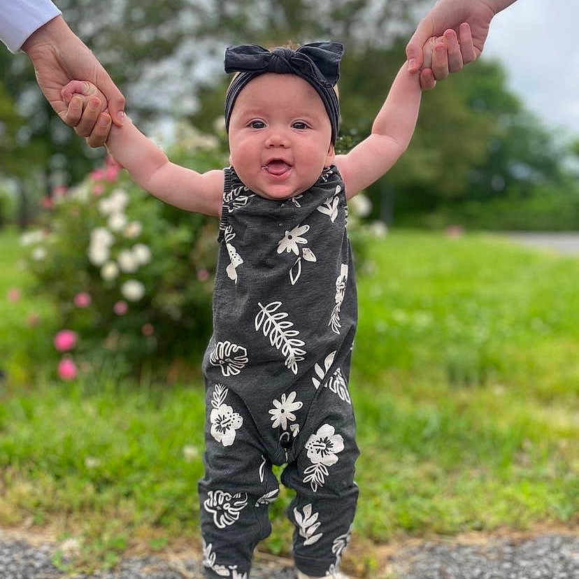 Waverly is registered to the contest to win money with this photo: baby, babylaughing, clothing, dress, face, footwear, formalwear, happy, head, jeans, pants, people, person, photography, portrait, sandal, sleeve, standing, suit, triumphant