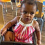 Emiyana joined the competition — help win amazing prizes! toddler, child, high_chair, dress, striped, indoor, restaurant, wooden_chair, table, flooring, curly_hair, person, cute, casual, seated, expression, daylight, furniture, skin, young