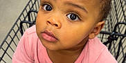 Emiyana joined the competition — help win amazing prizes! toddler, child, shopping_cart, grocery_store, curious, holding, pink_shirt, face, eyes, hands, floor, water_bottles, sitting, person, retail, indoor, expression, clothing, baby, cart