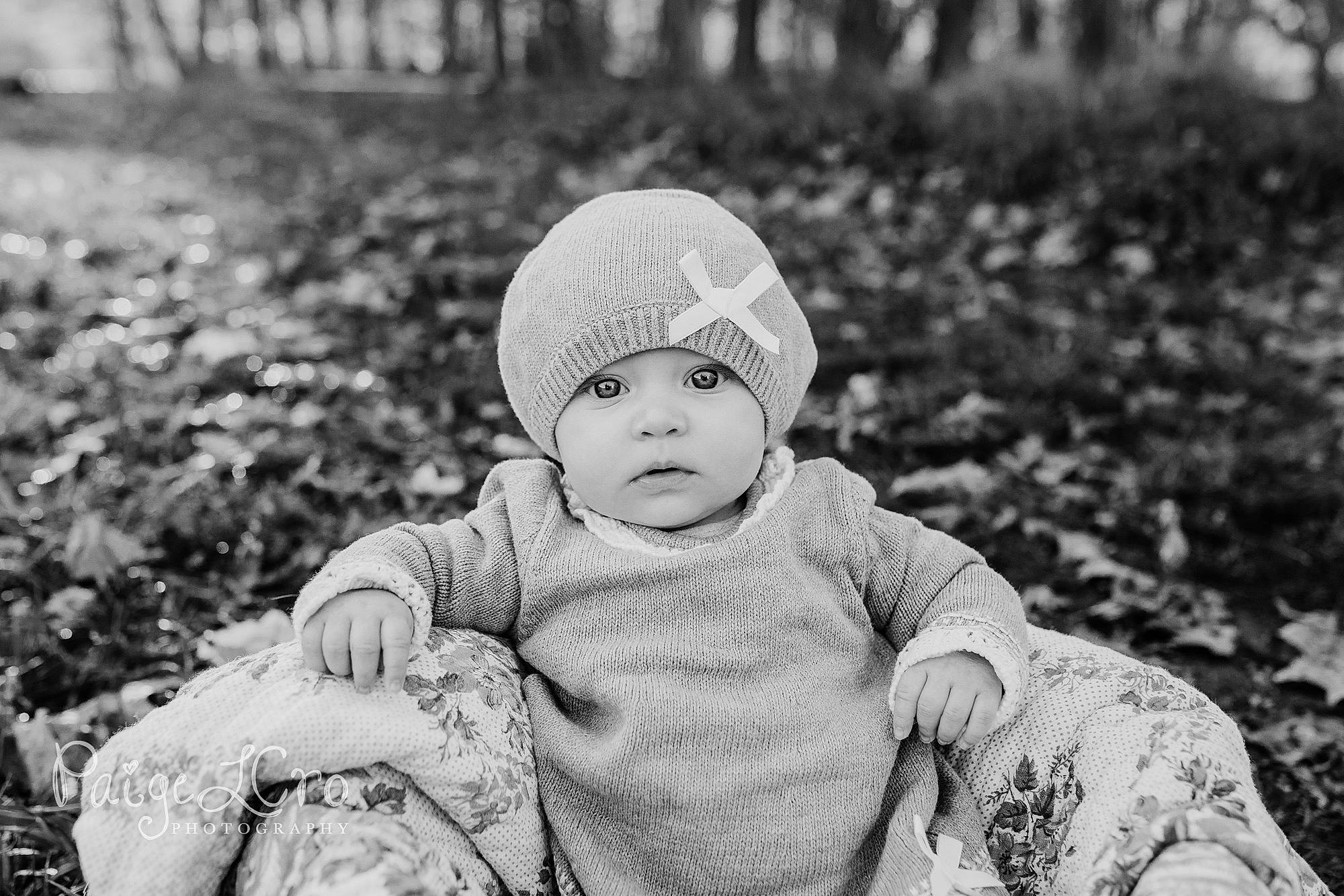 Ellie is registered to the contest to win money with this photo: baby, baby_toddler_clothing, black, black_and_white, cap, cheek, child, facial_expression, flash_photography, grass, happy, headwear, monochrome, monochrome_photography, people, people_in_nature, person, photograph, plant, sitting