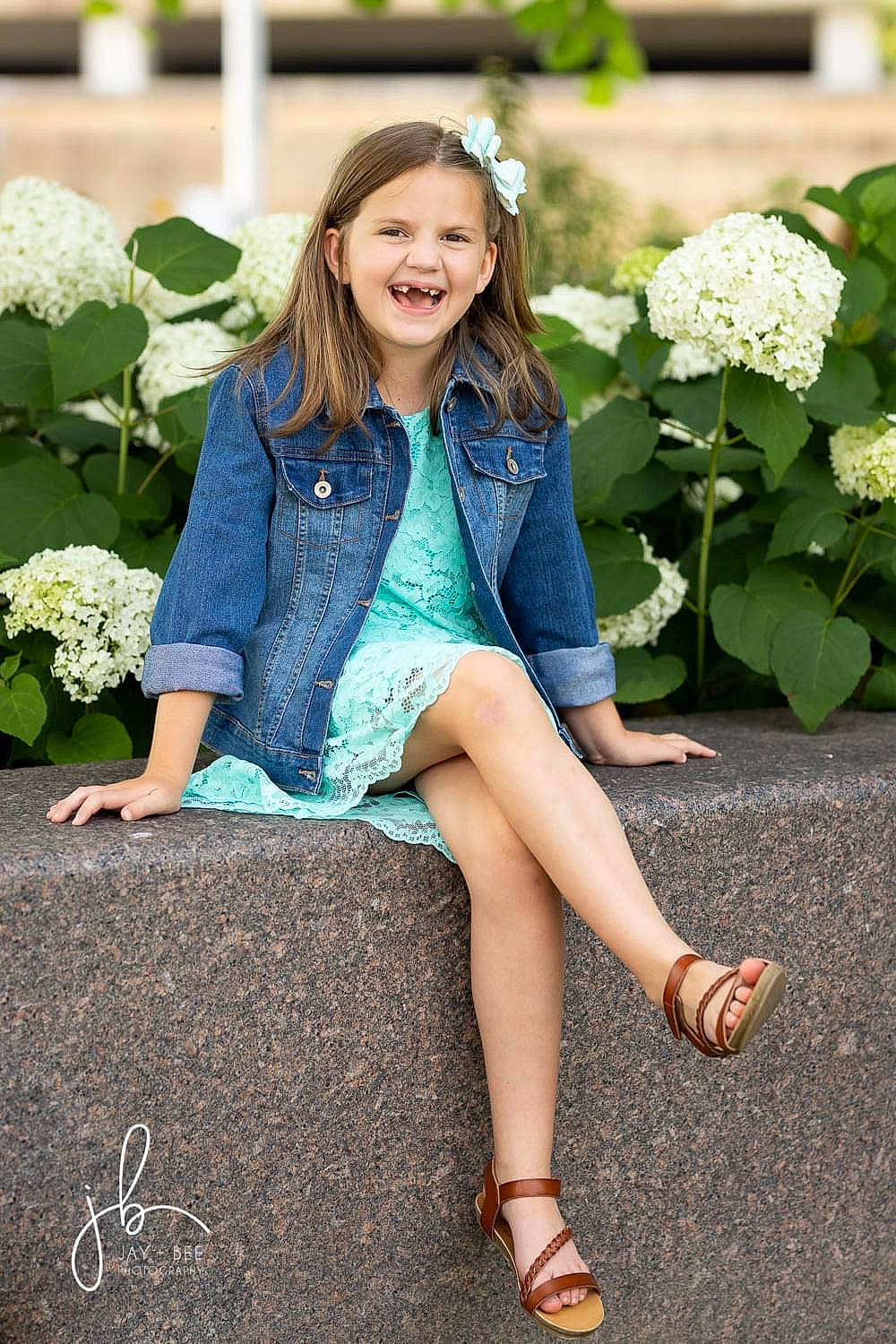 Emma is registered to the contest to win money with this photo: clothing, eye, face, facial_expression, flower, grass, hair, hairstyle, happy, joy, knee, person, photograph, plant, shoe, sleeve, smile, standing, street_fashion, textile