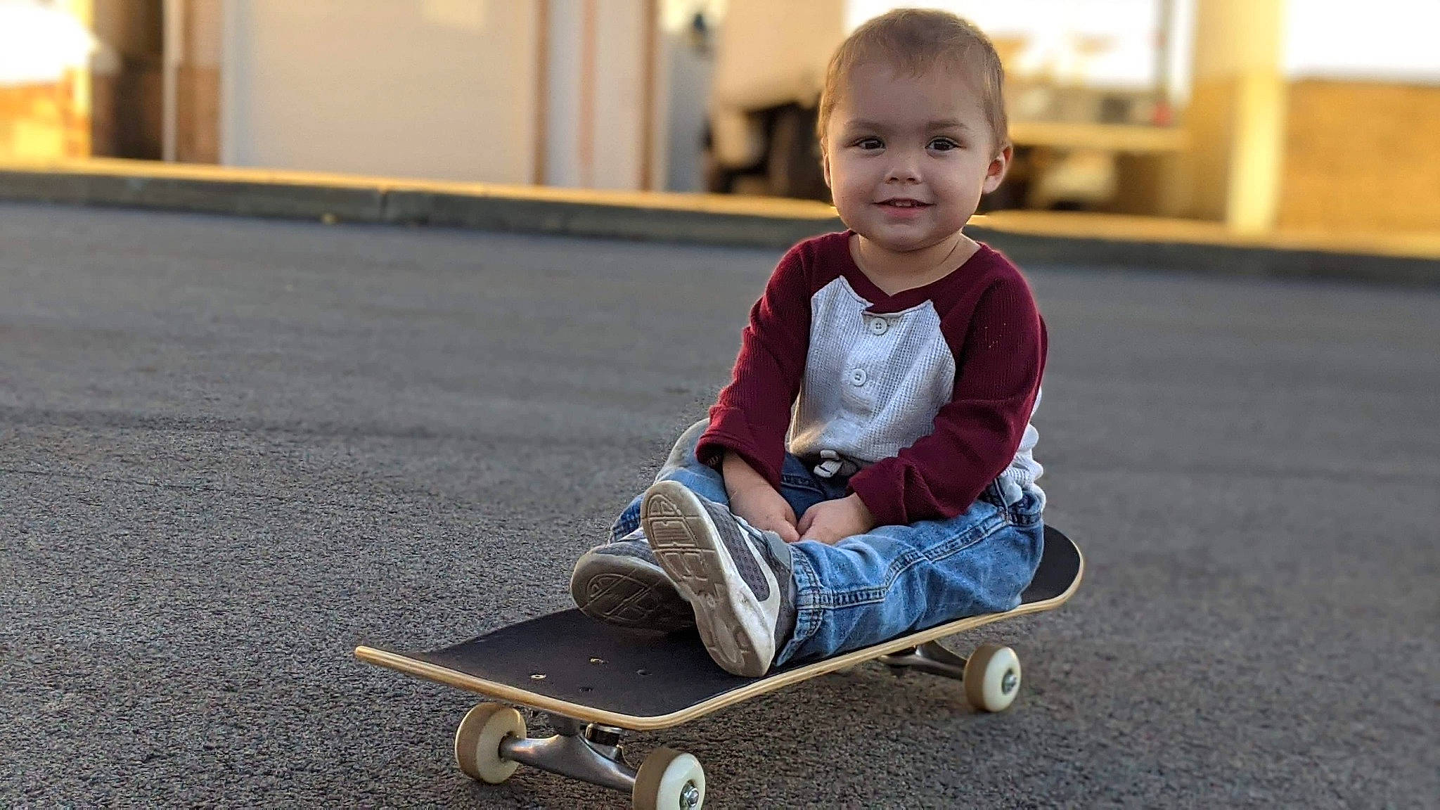 Jordon is registered to the contest to win money with this photo: child, joy, longboard, longboarding, person, play, recreation, rolling, sitting, skateboard, skateboarding_equipment, smile, sports_equipment, toddler, vehicle