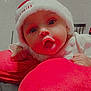 Aurora is registered to the contest to win money with this photo: baby, child, christmas_hat, closeup, cozy, cute, expression, face, fuzzy_hat, holiday, indoor, infant, person, portrait, red_cushion, resting, soft_texture, warm_colors, wide_eyes, young