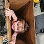 Fiadh is registered to the contest to win money with this photo: toddler, child, cardboard_box, smile, indoor, toy, rubber_duck, hand, hair, floor, carpet, furniture, couch, blanket, person, cute, playful, happy, curious, grip
