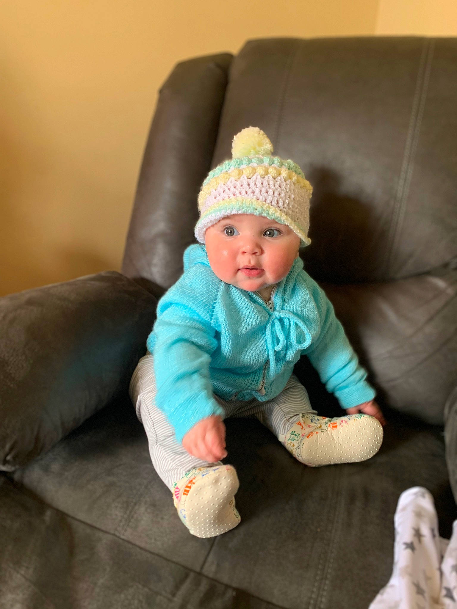 Wynter joined the competition — help win amazing prizes! arm, baby, baby_toddler_clothing, cap, child, comfort, couch, eye, fashion_accessory, flooring, headgear, headwear, knit_cap, leg, person, sitting, sleeve, sock, toddler, wood