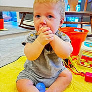 Calyn is registered to the contest to win money with this photo: baby, child, infant, sitting, hands, clasped_hands, blue_eyes, blonde_hair, yellow_blanket, toys, orange_bucket, rocking_chair, indoor, floor, cute, playing, clothing, person, home, portrait