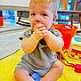 baby, child, infant, sitting, hands, clasped_hands, blue_eyes, blonde_hair, yellow_blanket, toys, orange_bucket, rocking_chair, indoor, floor, cute, playing, clothing, person, home, portrait
