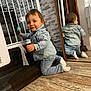 toddler, child, denim_jacket, denim_jeans, socks, mirror, wooden_floor, stair_gate, indoor, smile, reflection, wall, curious, baby, playful, face, kneeling, person, home, casual_clothing
