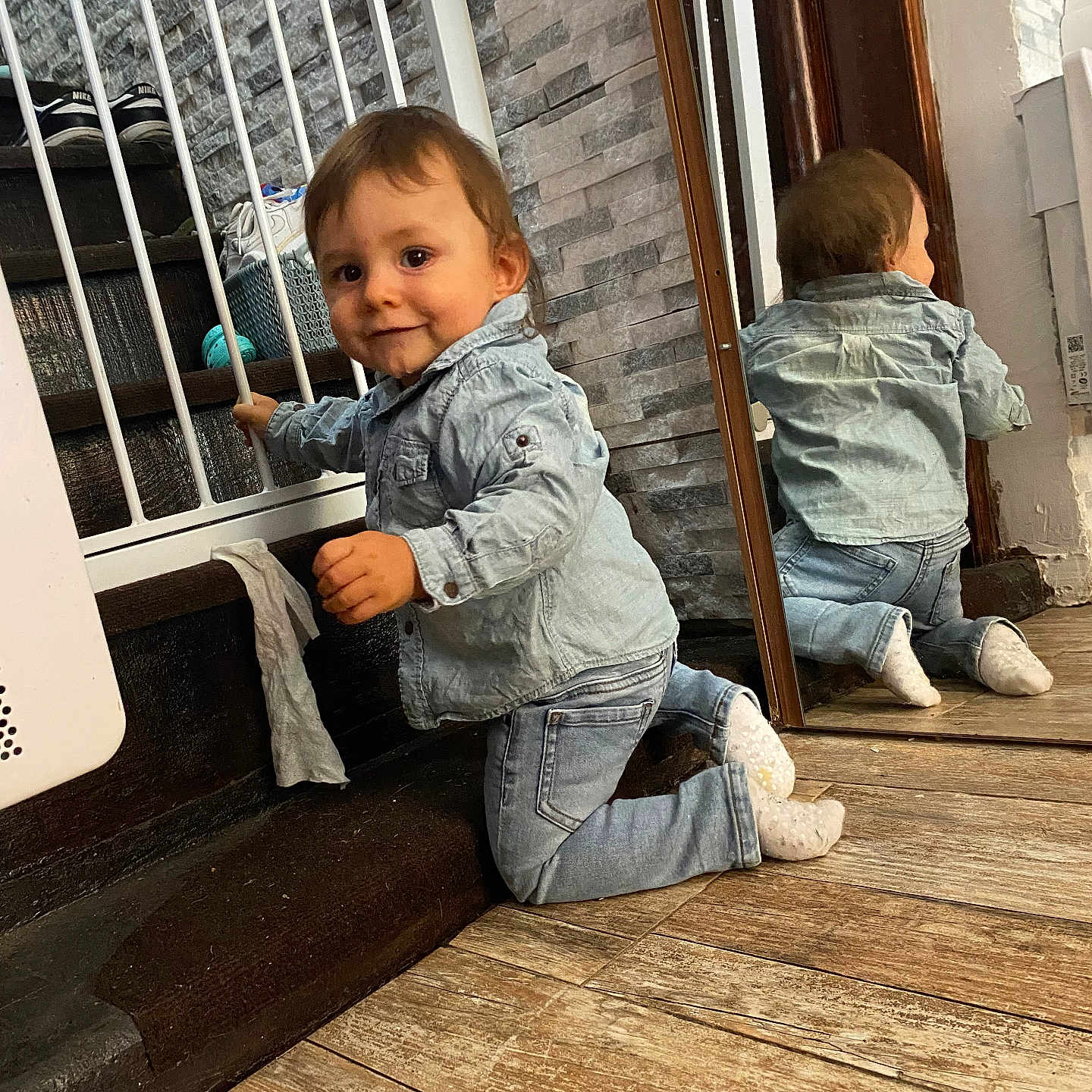Alessyo a rejoint le concours — aidez-le/la à gagner de superbes lots ! baby, casual_clothing, child, curious, denim_jacket, denim_jeans, face, home, indoor, kneeling, mirror, person, playful, reflection, smile, socks, stair_gate, toddler, wall, wooden_floor