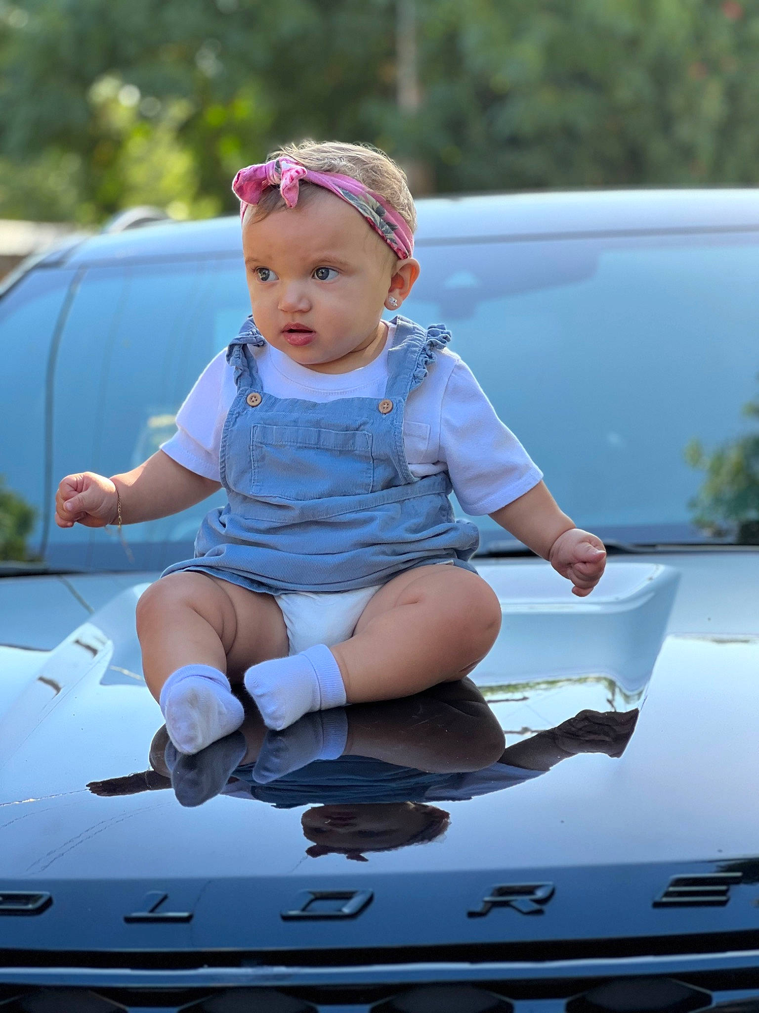 Leilani is registered to the contest to win money with this photo: automotive_design, automotive_exterior, automotive_lighting, automotive_tire, automotive_wheel_system, bumper, car, child, electric_blue, fun, hand, happy, headwear, hood, motor_vehicle, person, personal_luxury_car, recreation, toddler, trunk