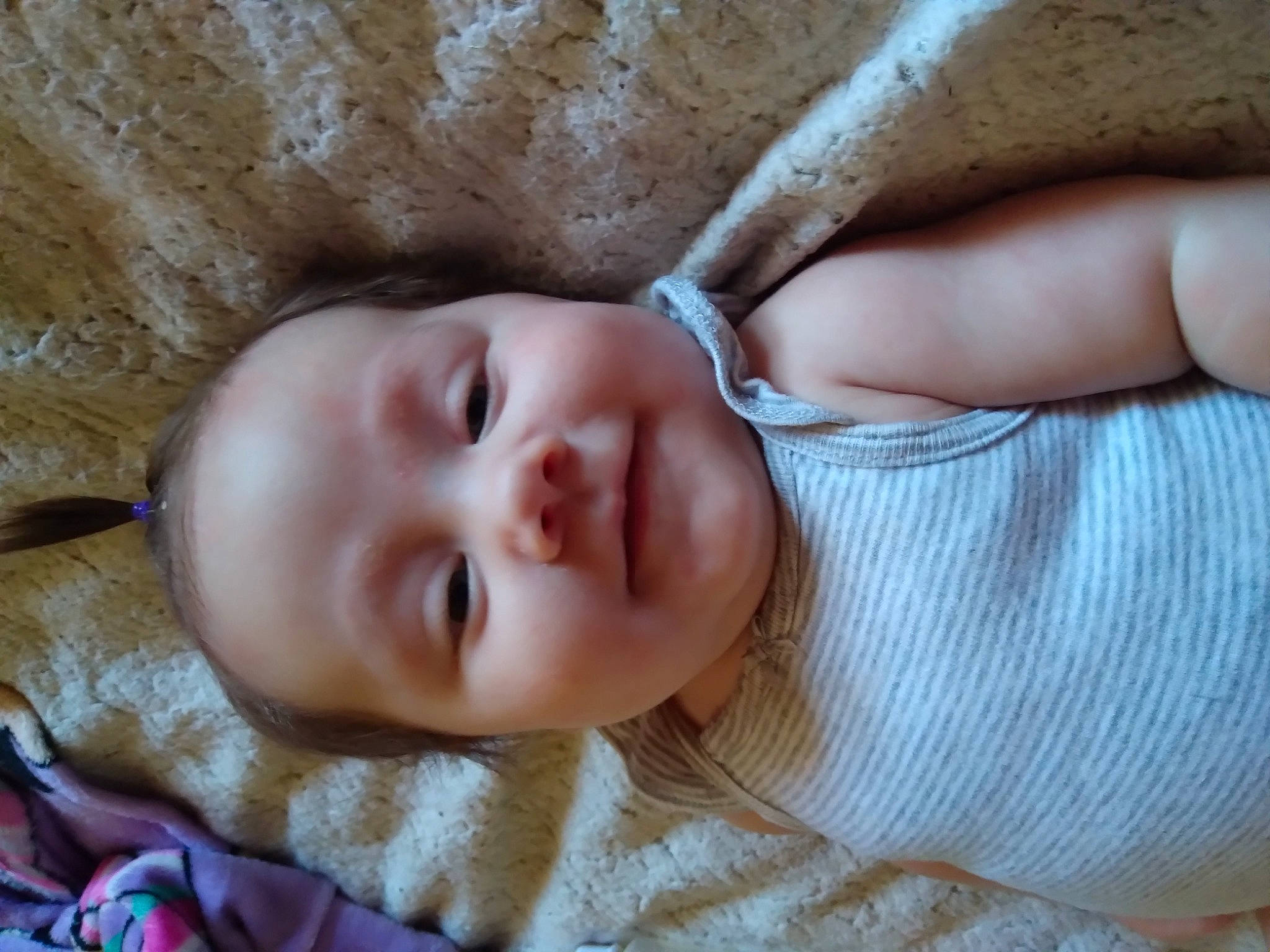 Freyja is registered to the contest to win money with this photo: baby, baby_toddler_clothing, cheek, child, close_up, comfort, ear, eye, eyebrow, face, finger, grass, head, iris, joy, linens, lip, mouth, nose, person