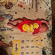 Darron is registered to the contest to win money with this photo: animal_characters, baby, carpet, cute, feet, hand, illustration, infant, lying_down, milestone_blanket, months, newborn, numbers, onesie, portrait, red_clothing, soft_texture, sticker, thanksgiving, winnie_the_pooh