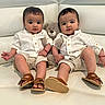 baby, twin_babies, toddler, white_shirt, beige_shorts, brown_sandals, plush_toy, teddy_bear, couch, white_couch, indoor, cute, child, sitting, smiling, portrait, furniture, person, infant, matching_clothes