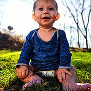 Marius joined the competition — help win amazing prizes! baby, child, smiling, sitting, grass, outdoor, blue_shirt, diaper, drool, sunlight, nature, happy, barefoot, face, head, person, trees, daylight, cute, young