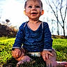 baby, child, smiling, sitting, grass, outdoor, blue_shirt, diaper, drool, sunlight, nature, happy, barefoot, face, head, person, trees, daylight, cute, young