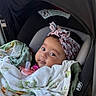 baby, car_seat, blanket, pacifier, headband, infant, child, portrait, indoors, soft_fabric, clothing, seatbelt, cute, young_child, car_interior, canopy, resting, wrapped, face, looking
