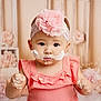 baby, child, girl, pink_dress, headband, flower, cake_frosting, messy, hands, face, portrait, indoor, decorations, soft_colors, cute, young_child, celebration, smiling, closeup, adorable
