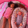 Gervonta is registered to the contest to win money with this photo: child, baby, tent, sibling, sleeping, baby_nest, pink, curly_hair, romper, carpet, wood_floor, indoor, calm, peaceful, cute, family, love, relaxing, patterned_fabric, portrait