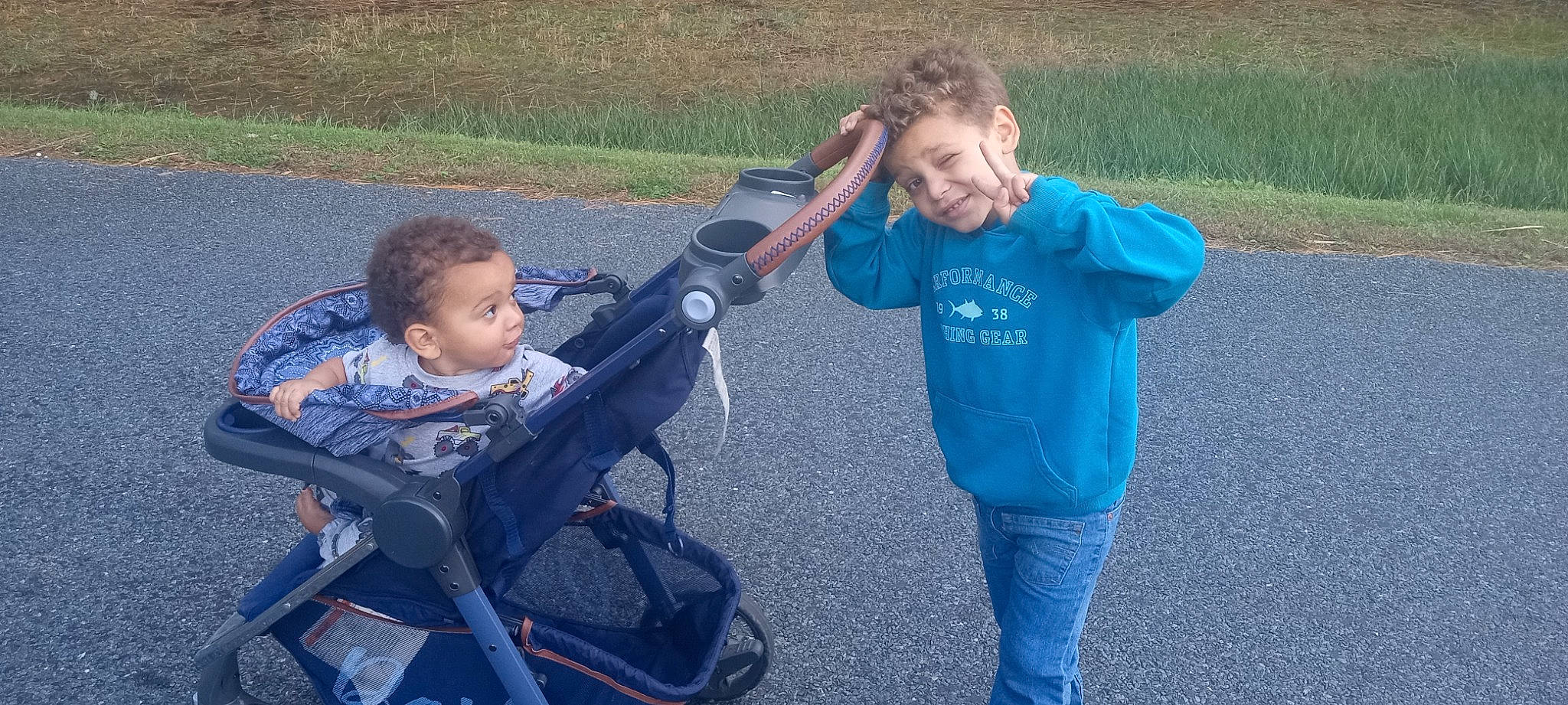 Kynstin is registered to the contest to win money with this photo: baby, baby_carriage, baby_products, child, electric_blue, fun, grass, joy, leisure, person, plant, public_space, recreation, sitting, smile, soil, t_shirt, tire, toddler, travel