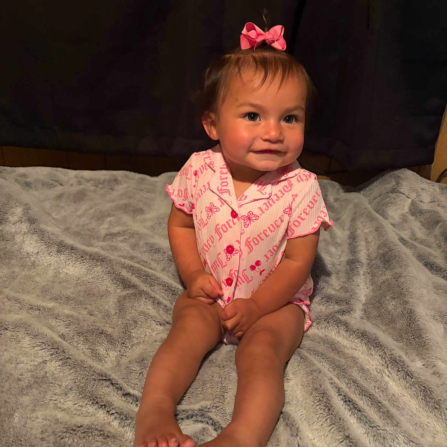 Ariella joined the competition — help win amazing prizes! toddler, child, baby, pajamas, pink_bow, sitting, blanket, soft_texture, indoor, smile, cute, face, legs, feet, hair, person, cozy, portrait, expression, young