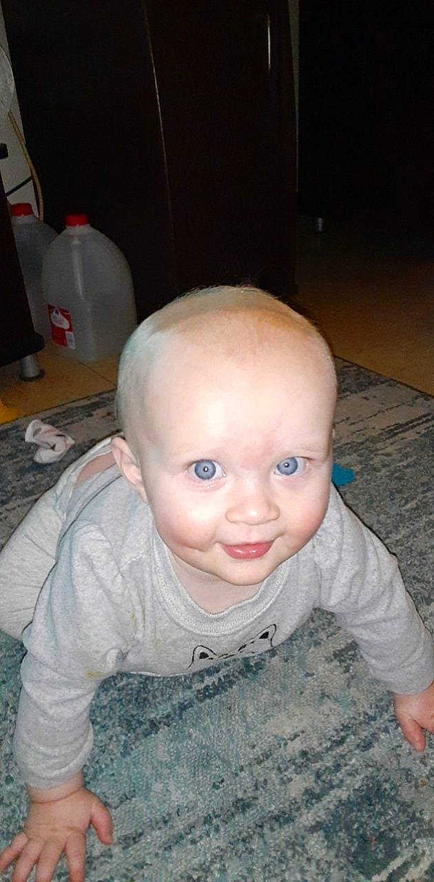 Paris is registered to the contest to win money with this photo: baby, baby_toddler_clothing, bottle, cheek, chin, ear, eye, eyelash, flooring, forehead, gas, iris, mouth, nose, person, plastic_bottle, skin, sleeve, smile, toddler