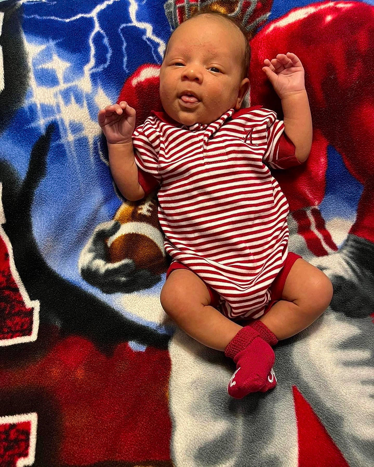 Kylan is registered to the contest to win money with this photo: baby, baby_toddler_clothing, cheek, child, comfort, event, face, facial_expression, finger, fun, happy, holiday, human_body, lap, pattern, person, pink, red, skin, textile