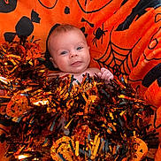 Reign joined the competition — help win amazing prizes! baby, infant, blanket, orange, halloween, tinsel, decoration, face, smile, cute, festive, holiday, child, celebration, cozy, soft, indoors, portrait, happy, person