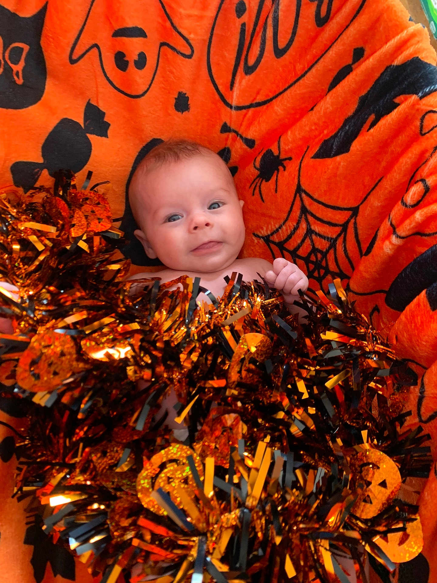Reign joined the competition — help win amazing prizes! baby, infant, blanket, orange, halloween, tinsel, decoration, face, smile, cute, festive, holiday, child, celebration, cozy, soft, indoors, portrait, happy, person