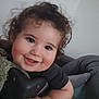 Joud participe au concours pour gagner de l'argent avec cette photo : baby, child, smiling, curly_hair, indoor, close_up, face, person, cute, happy, hand, skin, infant, black_clothing, soft_light, head, young_child, chubby_cheeks, expression, portrait