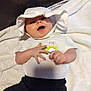 Keira Marie is registered to the contest to win money with this photo: baby, infant, hat, white_clothing, smiling, happy, toddler, blanket, indoor, couch, person, cute, child, soft_texture, casual_clothing, relaxed, baby_hands, portrait, headwear, cozy