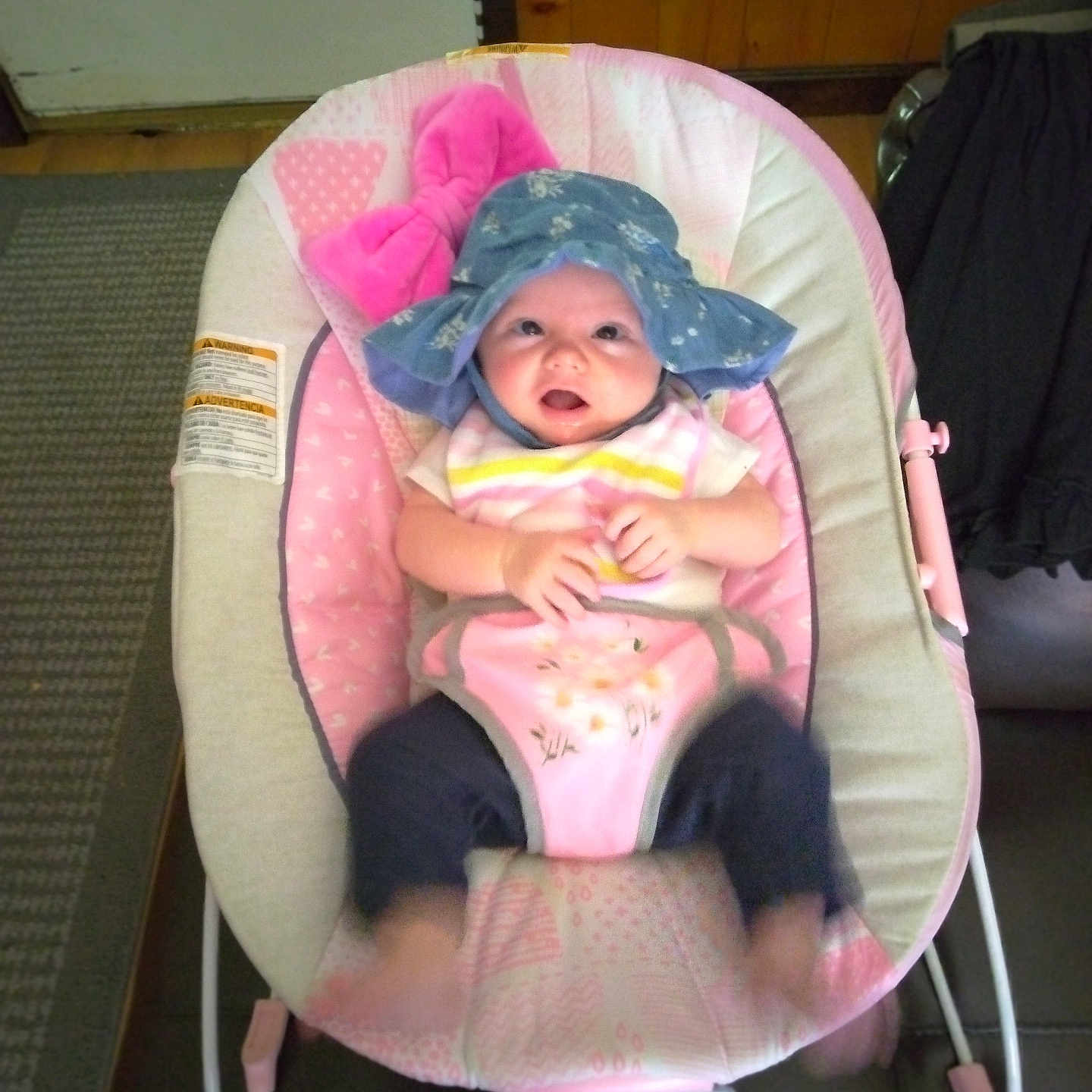 Keira Marie is registered to the contest to win money with this photo: baby, baby_accessories, baby_clothing, baby_face, baby_feet, baby_fun, baby_gear, baby_hands, baby_legs, baby_play, baby_seat, baby_toys, bib, blue_hat, carpet, indoor, infant, pink_baby_rocker, smiling, wooden_wall