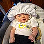 baby, infant, smile, white_hat, white_shirt, cat_design, black_pants, baby_seat, cushion, indoor, wooden_wall, window, curtain, face, person, happy, child, cute, young, seatbelt