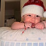 baby, bracelet, child, closeup, curious, cute, earrings, expression, face, hand, holiday, home, indoor, infant, person, pillow, santa_hat, skin, sleeping_aid, soft