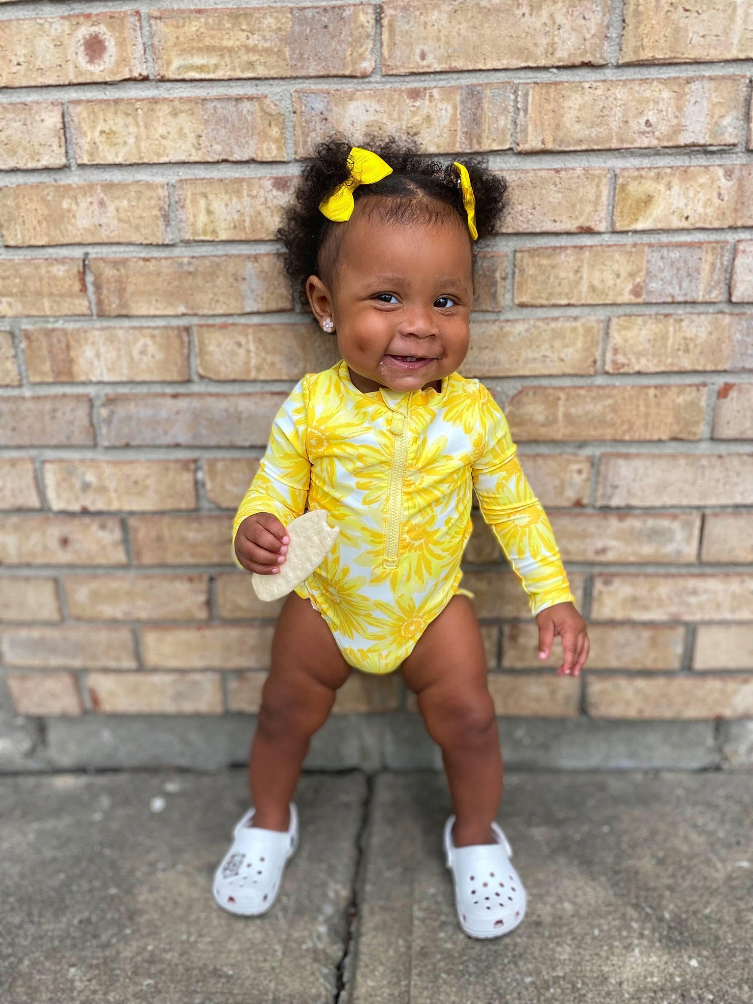 Nylani is registered to the contest to win money with this photo: baby, baby_toddler_clothing, brick, brickwork, child, costume, fun, grass, happy, head, headband, human_leg, jewellery, joy, magenta, pattern, person, sitting, sleeve, smile