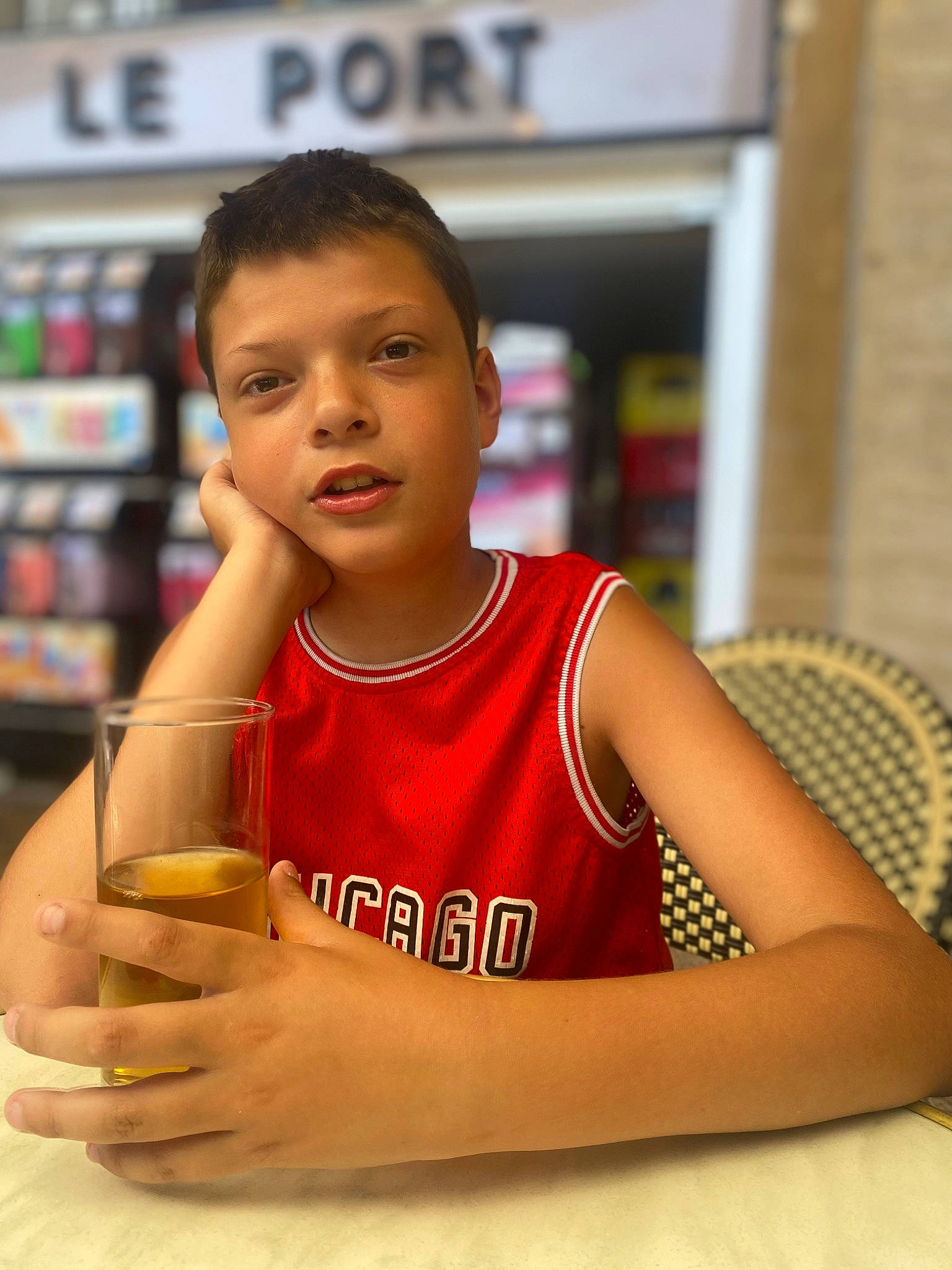 Noa participe au concours pour gagner de l'argent avec cette photo : arm, chair, chest, child, drink, elbow, flooring, fun, hand, happy, human_leg, leisure, person, room, shelf, sitting, sportswear, t_shirt, thumb, vest