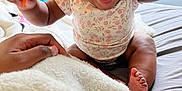 Avery is registered to the contest to win money with this photo: baby, child, toy, bed, blanket, hand, indoor, happy, smiling, person, window, clothing, skin, foot, sitting, expression, furniture, room, light, comfort