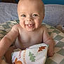 baby, smiling, tongue_out, soft_book, cushion, indoor, child, cute, happy, portrait, infant, playful, colorful, toy, person, face, skin, head, bare_chest, background