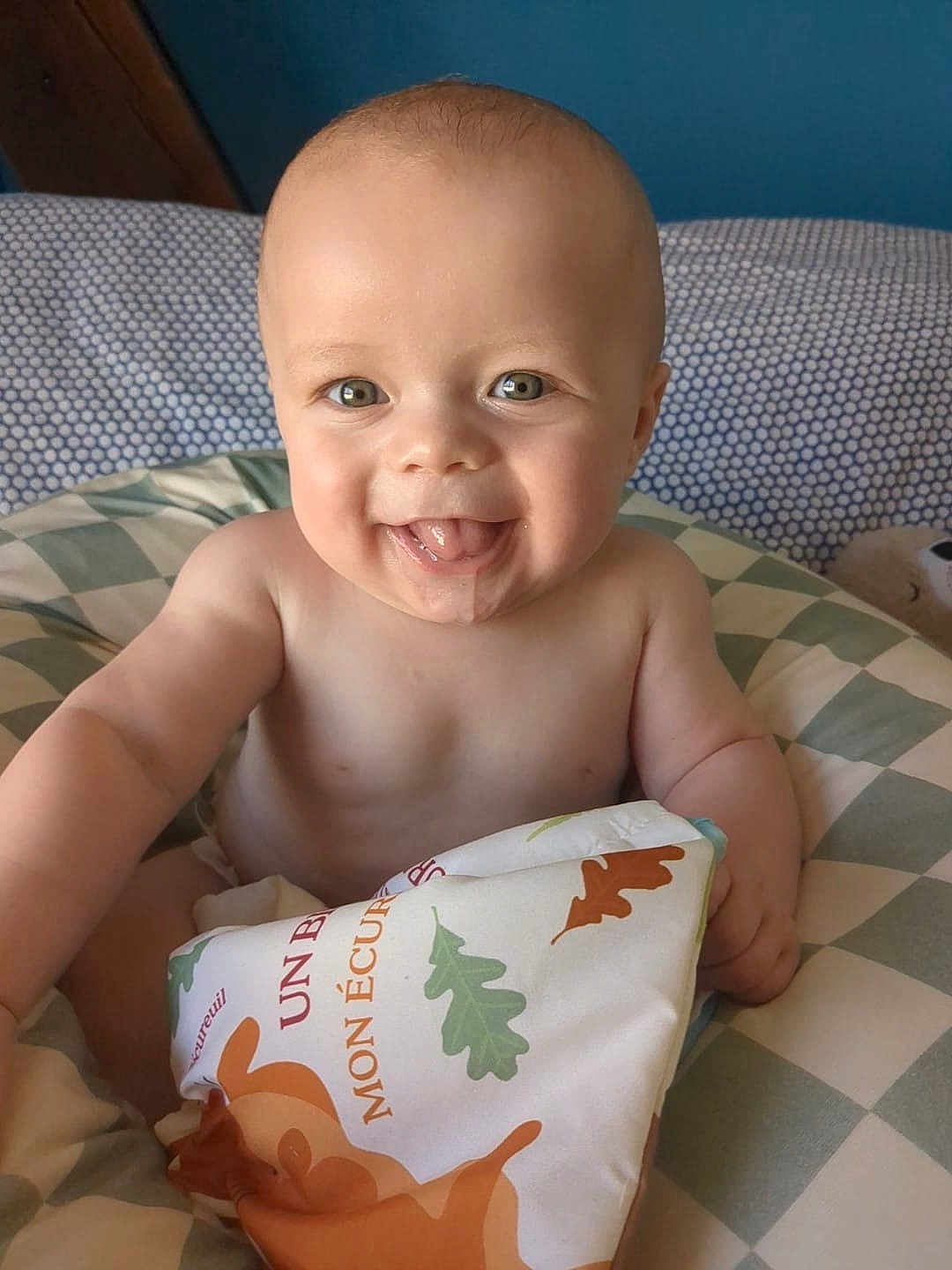Alexandre a rejoint le concours — aidez-le/la à gagner de superbes lots ! baby, smiling, tongue_out, soft_book, cushion, indoor, child, cute, happy, portrait, infant, playful, colorful, toy, person, face, skin, head, bare_chest, background