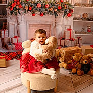Manon participe au concours pour gagner de l'argent avec cette photo : baby, chair, child, christmas_tree, cozy, cute, festive, fireplace, gifts, holiday, indoor, ornaments, plush_toys, portrait, presents, red_skirt, smiling, teddy_bear, white_sweater, wooden_floor