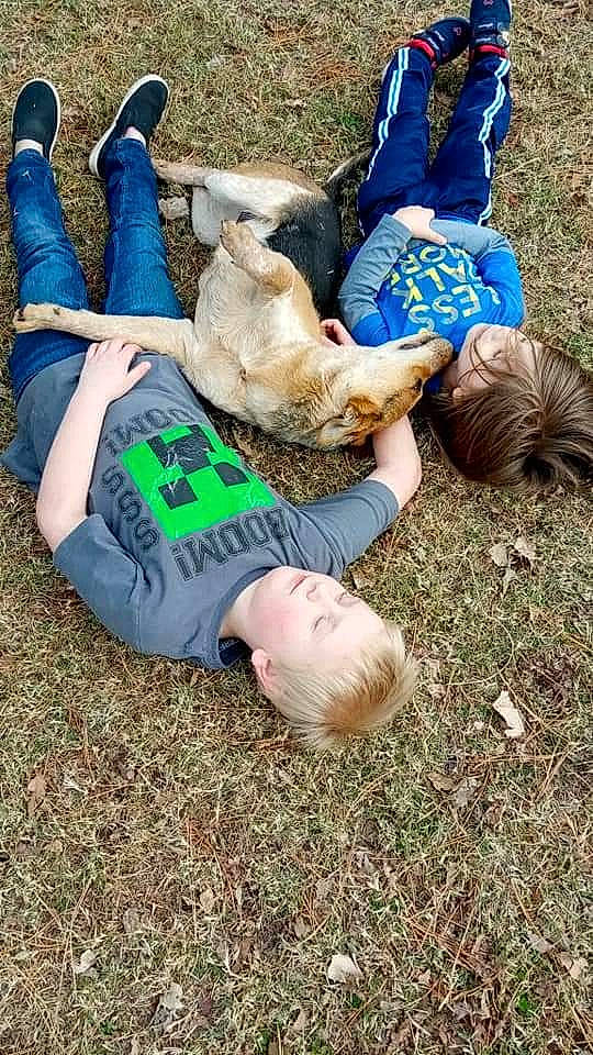 Red is registered to the contest to win money with this photo: fun, grass, grass_family, hand, happy, human_leg, jeans, joint, lawn, leg, leisure, people_in_nature, recreation, shoe, sitting, sneakers, soil, t_shirt, thigh, vertebrate