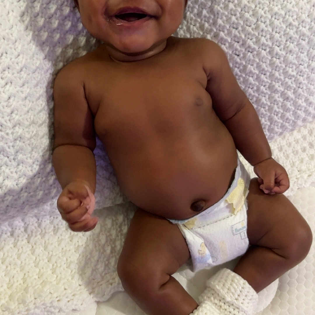 Samir Baldwin joined the competition — help win amazing prizes! baby, blanket, child, comfort, cute, diaper, face, happy, human, indoors, infant, knitted_booties, lying_down, newborn, one_person, skin, smiling, soft_texture, sweet, toddler