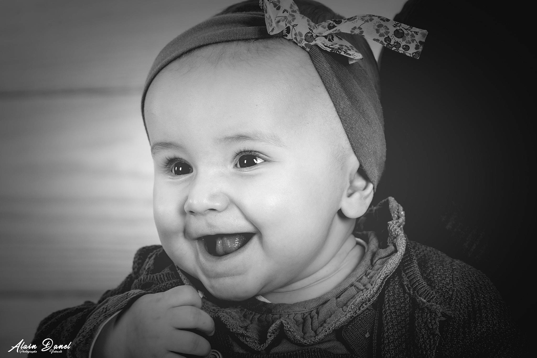 Orlane participe au concours pour gagner de l'argent avec cette photo : baby, black_and_white, cheek, child, clothing, ear, eye, eyebrow, face, flash_photography, happy, head, headgear, iris, person, skin, smile, standing, style, toddler